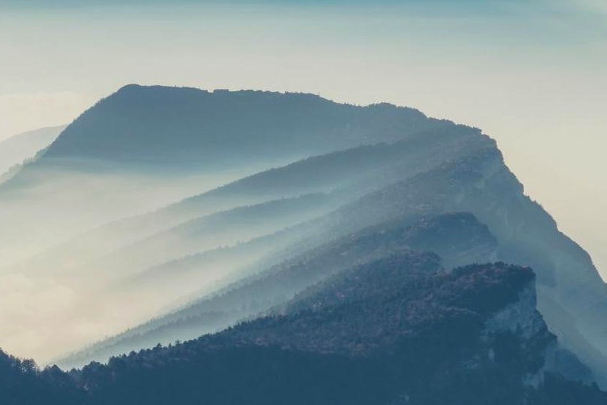 O nevoeiro que assenta no vale ao amanhecer desfaz-se quando o vento roda.